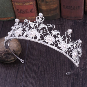 Detailed close-up of Baroque silver bridal crown with pearls on vintage book background