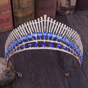 Macro shot of gold peacock crown with blue crystals on a vintage book backdrop