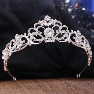 Sparkling silver bridal crown with intricate rhinestone details on a vintage dark background