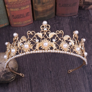 Detail of vintage gold sunflower crown with intricate floral carvings and white pearls
