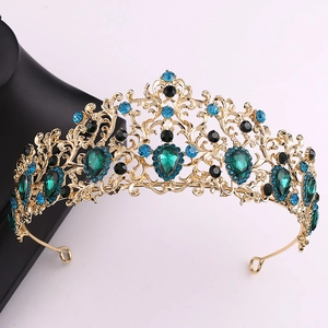 Close-up of vintage baroque crown with emerald green gems and blue rhinestones