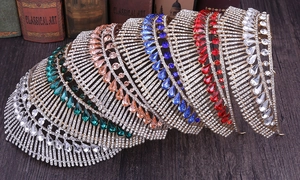 Detail view of five multicolor crystal bridal tiaras with peacock tail patterns on wood