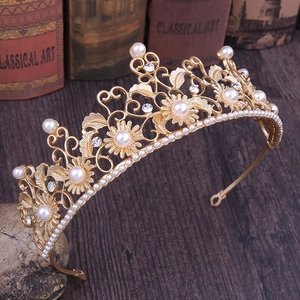Detail view of a vintage baroque crown with gold plating, white pearls, and clear crystals