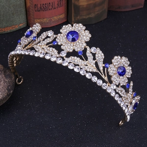 Dettaglio della corona d'oro vintage con gemme blu e motivi floreali in cristallo