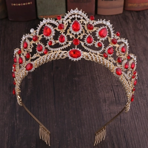 Close-up of golden bridal tiara with ruby red teardrop crystals and secure hair comb