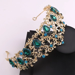 Detailed shot of golden leaf tiara with emerald waterdrop gems and vintage filigree