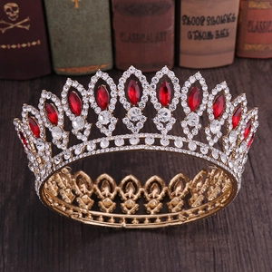 Baroque gold bridal crown with red rubies and crystal rhinestones on vintage wooden background