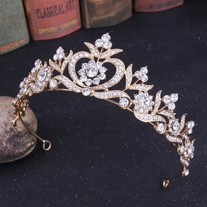 Détail de couronne de mariée dorée avec motifs de feuilles et cœurs en strass