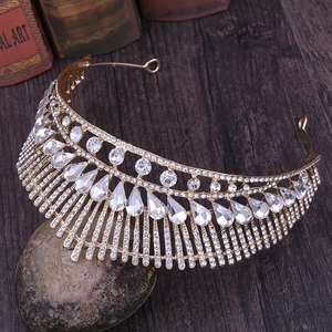Close-up of golden bridal crown with peacock tail rhinestone pattern on vintage stone