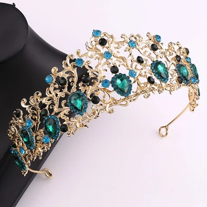 Detailed side view of a bridal tiara with green teardrop crystals and gold filigree