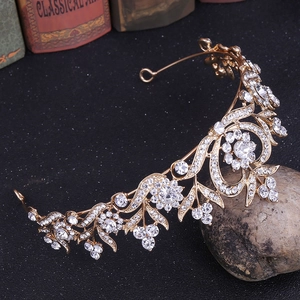 Détail d'une couronne de mariée dorée avec motifs de feuilles et strass étincelants