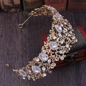 Detailed 45-degree view of a golden bridal tiara featuring sparkling white rhinestones