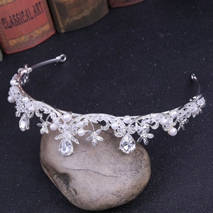 Détail d'un diadème argenté avec fleurs, perles blanches et pendentifs goutte en cristal