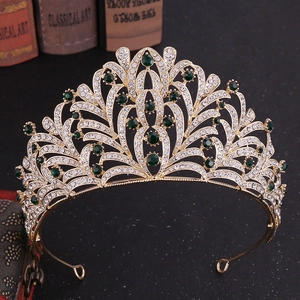 Detailed close-up of emerald green crystals and rhinestones set in golden bridal crown