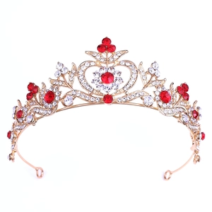 Détail d'une couronne de mariée baroque dorée avec des strass rouges et blancs