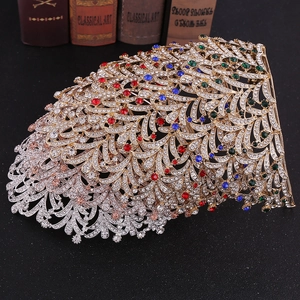 Detailed close-up of peacock feather crown with multicolor rhinestones on gold base