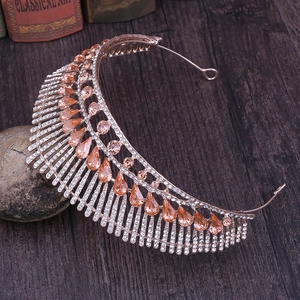 Close-up of rose gold wedding crown with champagne crystals on a vintage wood desk