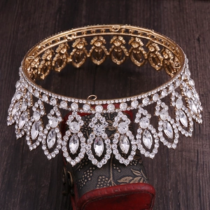 Detailed close-up of a gold baroque bridal crown with crystal rhinestones on a jewelry box