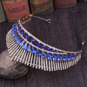 Macro detail of royal tiara featuring blue crystals and white rhinestones on golden frame