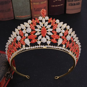 Exquisite gold tiara with red and white rhinestones on vintage books background