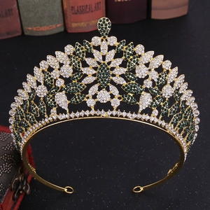 Detailed macro view of vintage gold crown with emerald green and white rhinestones
