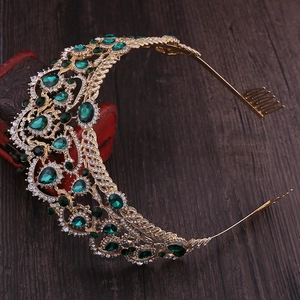 Detail view of gold bridal tiara with emerald green gems and white rhinestones