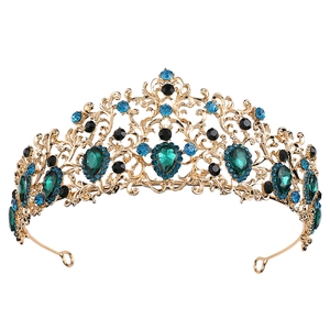 Close-up of golden crown with intricate vine patterns and inlaid green water drop gemstone