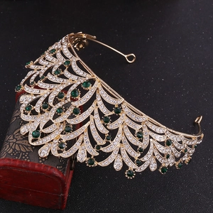 Detailed macro of golden bridal crown featuring green gemstones and leaf crystal patterns