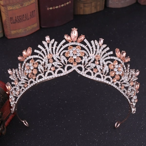 Détail d'un diadème de mariée en or rose serti de strass champagne sur des livres
