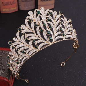 Detail of leaf rhinestone bridal crown with emerald green stones on a vintage background