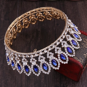 Detailed macro view of Baroque gold bridal crown with blue gemstones and white rhinestones