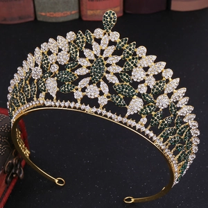 Close-up of luxury gold crown with green rhinestones set against vintage books