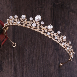 Close-up of golden bridal crown with leaf patterns and sparkling crystal rhinestones