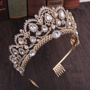 Detailed macro view of vintage gold bridal crown with crystals on dark wood surface