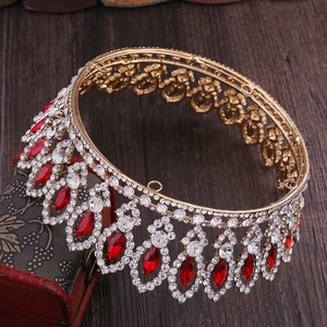 Detailed macro view of baroque gold bridal crown with red teardrop gems and rhinestones