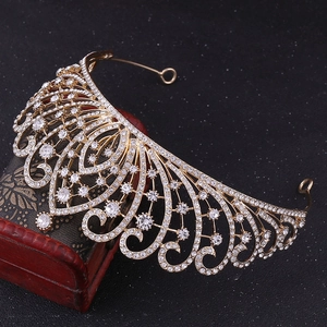 Close-up of golden Baroque bridal crown with white rhinestones on vintage wooden box