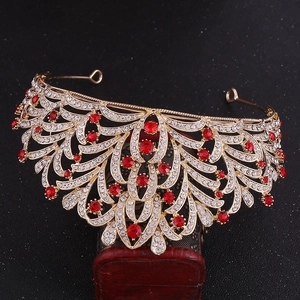 Detailed close-up of golden alloy bridal crown with red gemstones and white rhinestones