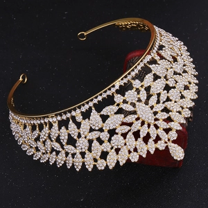 Close-up of luxury gold rhinestone crown resting on vintage wooden jewelry box