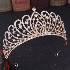 Close-up of golden Baroque bridal crown with crystals on a black glittering background