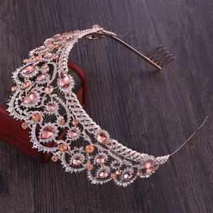 Detailed side view of rose gold bridal crown with champagne crystals on vintage wooden box