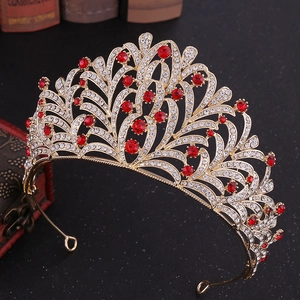 Close-up of golden bridal crown with red rhinestones on vintage background