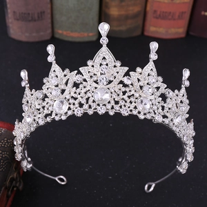 Detail of silver bridal crown featuring hollow carvings and teardrop crystal settings