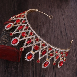 Détail d'un diadème de mariée doré vintage avec pierres rouges sur un coffret en bois