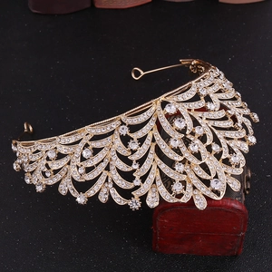 Close-up of golden leaf crown with clear rhinestones on a vintage wooden jewelry box