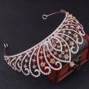 Detail view of Baroque bridal tiara with rhinestones resting on a vintage wooden box