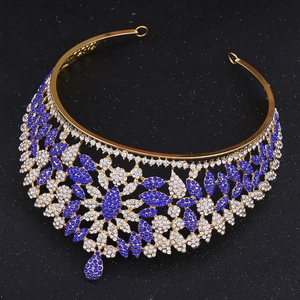 Macro detail of luxury gold crown featuring intricate blue and white rhinestone floral patterns