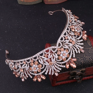 Détail du diadème de mariée en or rose avec strass champagne sur un coffre vintage