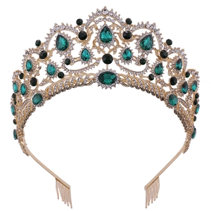 Detailed macro view of vintage gold bridal crown with emerald gemstones and floral patterns