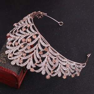 Detailed close-up of rose gold leaf tiara with champagne stones on vintage box