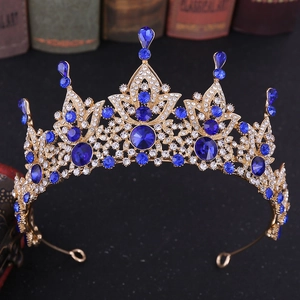 Detail of baroque gold crown featuring navy blue crystals and intricate white diamonds